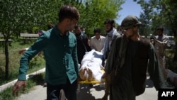 Afghan volunteers bring the body of a resident killed in a car-bomb attack to the Wazir Akbar Khan hospital in Kabul on May 31.