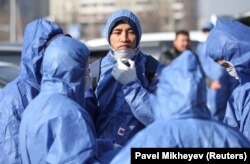 Специалисты в защитных костюмах проводят дезинфекционные работы на улицах Алматы. 27 марта 2020 года.