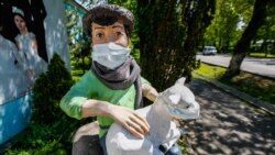 Скульптура мальчика с ягненком в медицинских масках в Алматы.