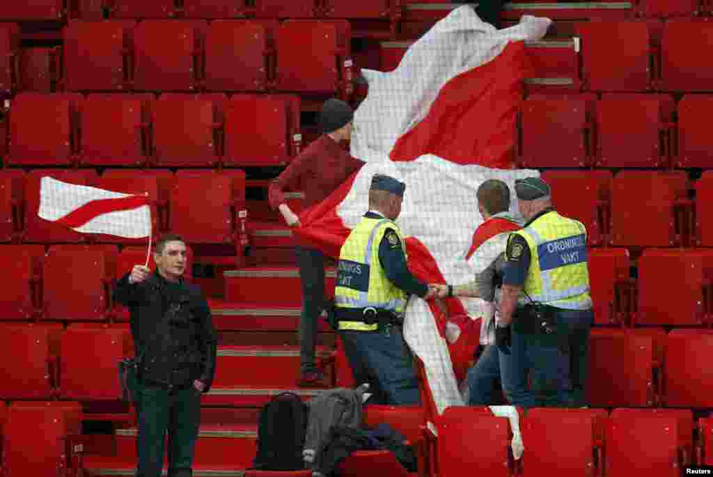 Security personnel stop a fan of Belarus from displaying a former Belarusian flag that the current government has outlawed at a 2013 world ice hockey championship match against Slovenia at the Globe Arena in Stockholm. (Reuters/Arnd Wiegmann) 