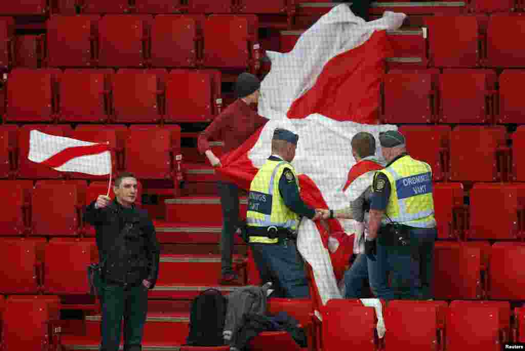 Security personnel stop a fan of Belarus from displaying a former Belarusian flag that the current government has outlawed at a 2013 world ice hockey championship match against Slovenia at the Globe Arena in Stockholm. (Reuters/Arnd Wiegmann)