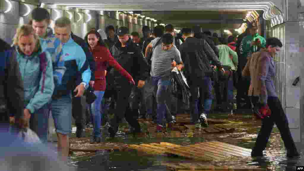 People walk on wooden boards inside a flooded underground pedestrian subway in Moscow. (AFP/Vasily Maksimov)