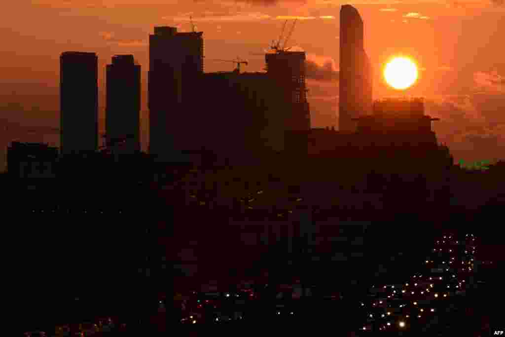 The sun sets behind skyscrapers and a traffic jam on the Sadovoe (Garden) Ring in Moscow. (AFP/Kirill Kudryavtsev)