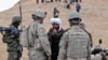 A local Afghan man from Baghdis Province talks through an interpreter (right) to a U.S. Army officer in 2011.