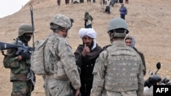 A local Afghan man from Baghdis Province talks through an interpreter (right) to a U.S. Army officer in 2011.