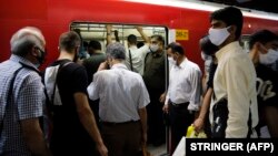 Iranians, mostly wearing face masks, are pictured at a metro station in the capital Tehran on June 10, 2020 amid the coronavirus Covid-19 pandemic crisis. 