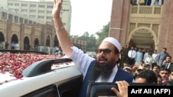 Hafiz Saeed, who has a $10 million U.S. bounty on his head, waves to supporters as he leaves a court in Lahore on October 19, 2017.