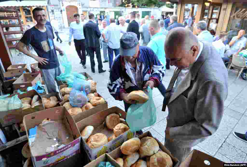 A Bosnian Muslim man buys paklama, or traditional bread, following early morning prayers on Eid Al-Fitr in Sarajevo.