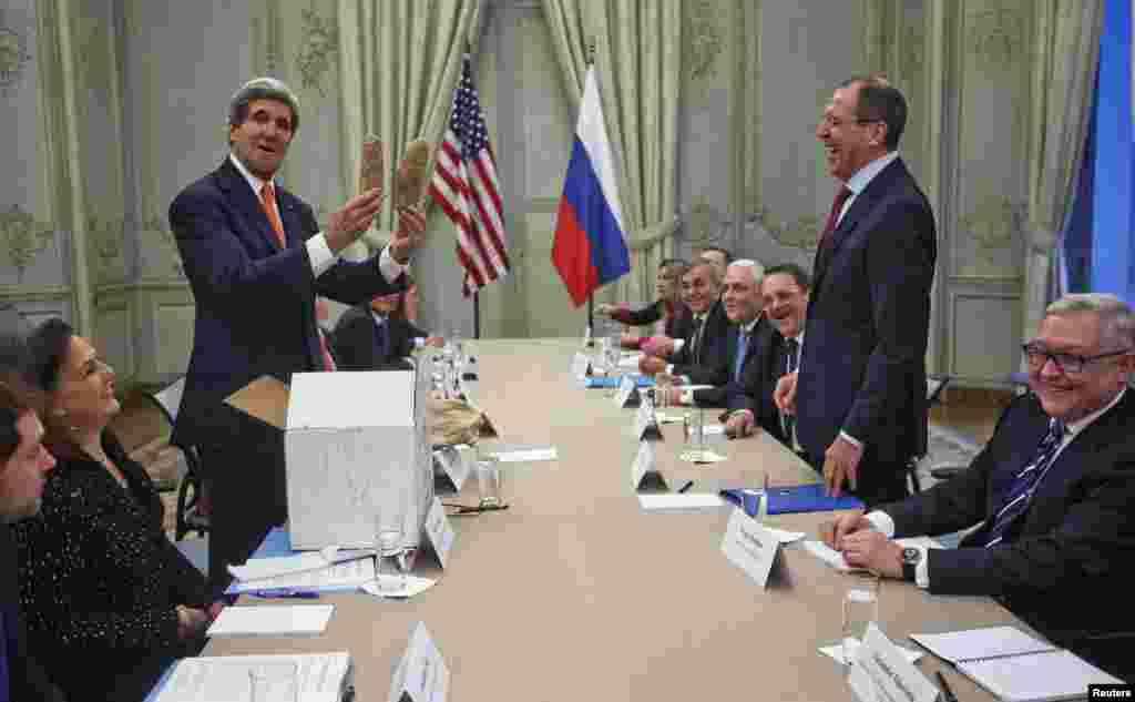 U.S, Secretary of State John Kerry (standing, left) holds up a pair of Idaho potatoes as a gift for Russian Foreign Minister Sergei Lavrov (standing, right) at the start of their meeting at the U.S. Ambassador's residence in Paris on January 13. (Reuters/Pablo Martinez Monsivais)