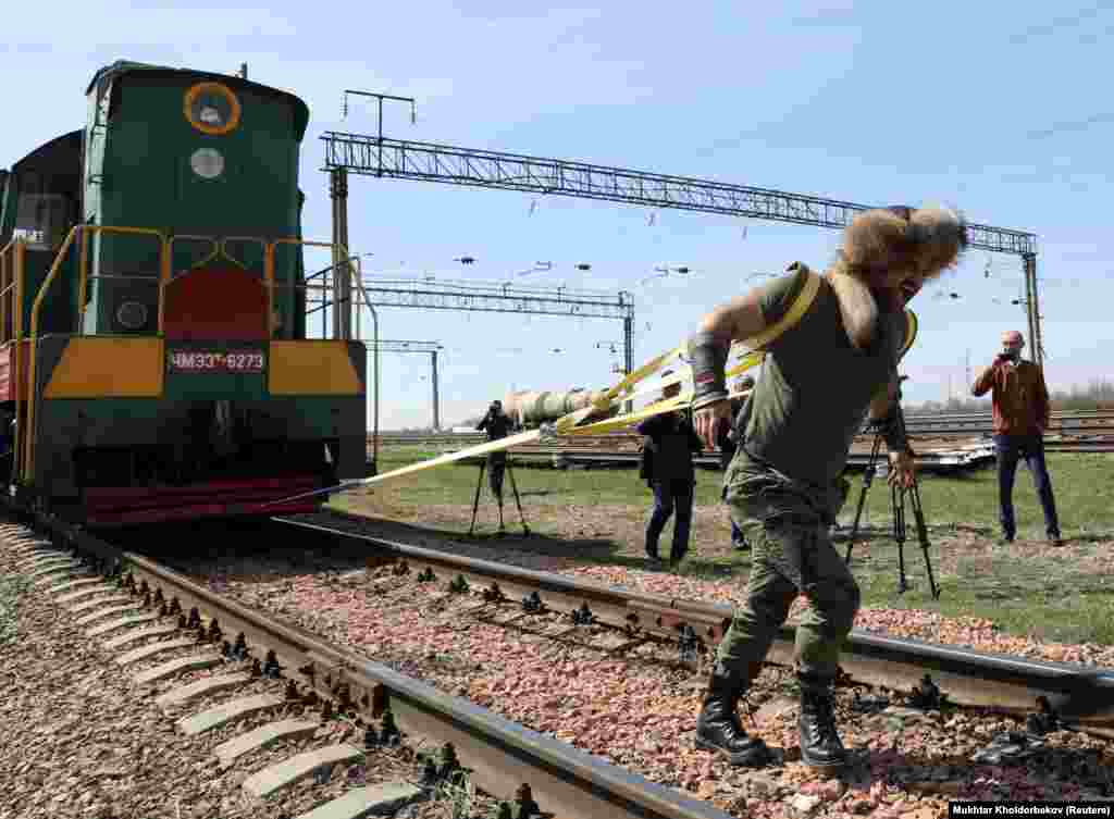 Gazak pälwany Sergeý Tsyrulnikow 148 tonnalyk lokomotiwi çekýär. (Reuters/Mukhtar Kholdorbekov)