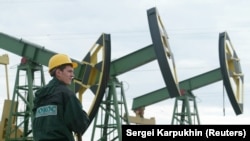 File picture shows a worker looking over the derricks at Yuganskneftegaz oil 