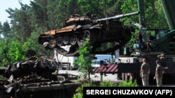 Українські військові прибирають знищені ЗСУ російські танки біля Дмитрівки на Київщині, червень 2022 року