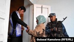 A woman casts her ballot amid tight security at a polling station in the troubled southern city of Osh.