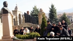 People offer memorial prayers at the tomb of late opposition leader Zamanbek Nurqadilov. (file photo)