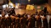 Supporters of the Iran-backed militant group hold the flags of Hezbollah and Amal Movement, as they stand in front of Lebanese army soldiers forming a barrier. November 25, 2019