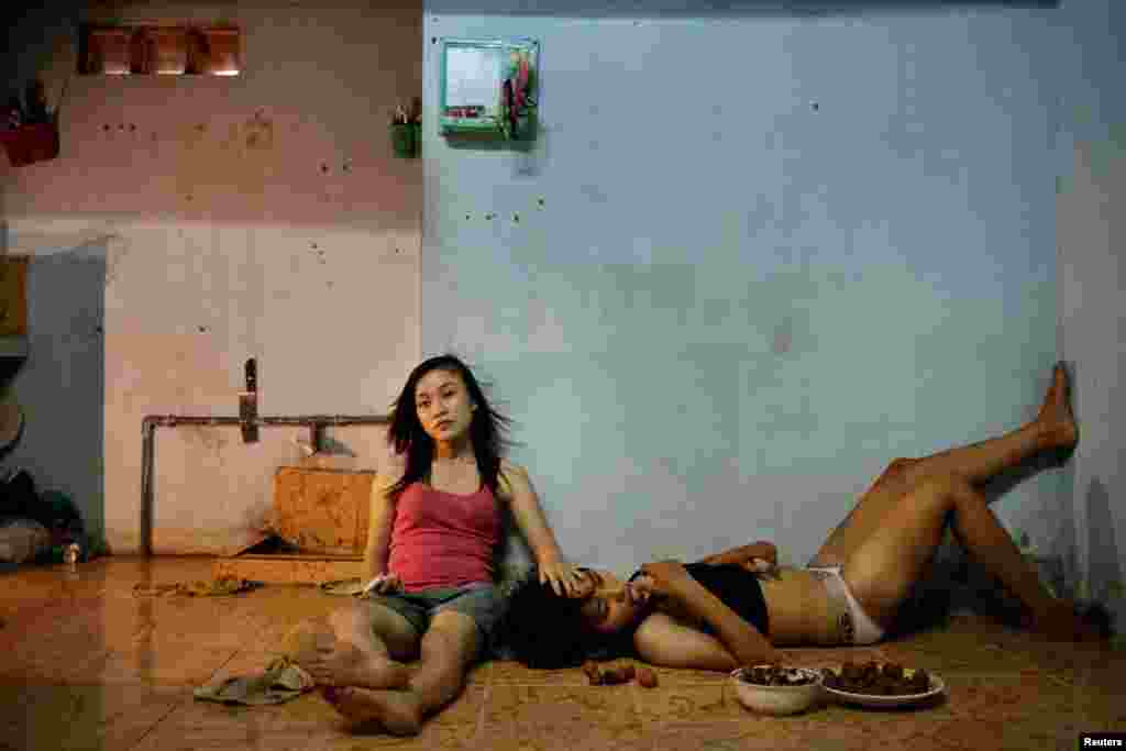 Maika Elan of Vietnam, a photographer working for Management of Story Tellers (MoST), won first prize in the Contemporary Issues Stories category with the series "The Pink Choice, Vietnam." This picture shows Phan Thi Thuy Vy and Dang Thi Bich Bay, who have been together for one year, watching television after a day of studying at school in Da Nang.