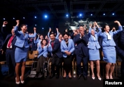 Члени китайської делегації святкують перемогу після оголошення результатів голосування