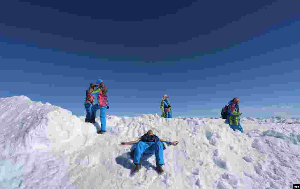 Games staff enjoy the sun near the Rosa Khutor Alpine Center.