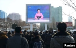 Прохожие на улицах Пхеньяна смотрят и слушают заявление телевидения КНДР об успешном испытании. 6 января