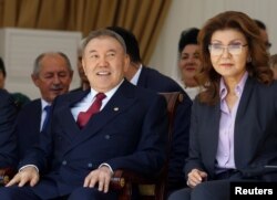 Нурсултан Назарбаев (слева) сидит со старшей дочерью Даригой на праздничном мероприятии. Алматы, 1 мая 2016 года.