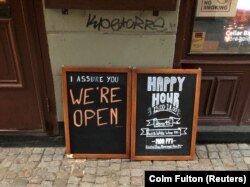 "Мы открыты!" – рекламная доска около бара в центре Стокгольма, 27 марта 2020 года
