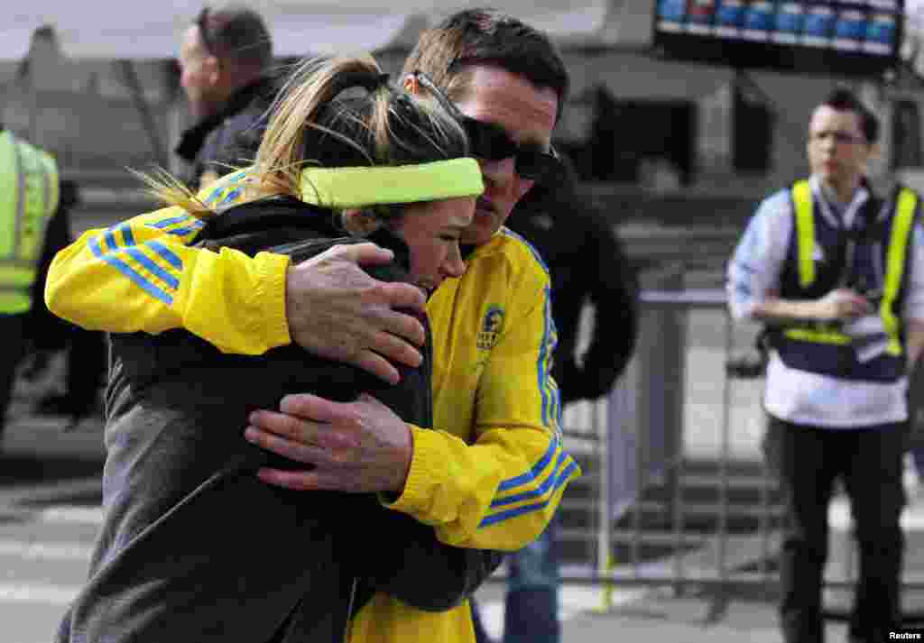 A woman is comforted by a man near a triage tent after explosions went off at the 117th Boston Marathon.