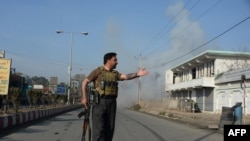 Afghan security personnel keep watch along a street after an attack from a building close to the Pakistan consulate in Jalalabad on January 13.