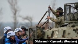 Военнослужащий Вооруженных сил Украины показывает оружие членам Специальной мониторинговой миссии ОБСЕ в селе Богдановка
