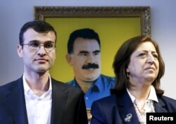 Officiali kurzi sirieni la deschiderea misiunii din Moscova, 10 februarie. In spate, portretul lui Abdullah Ocalan, șeful partidului kurzilor turci PKK, intemnițat pe viață în Turcia.