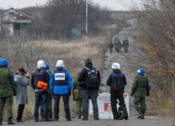Члени спостережної місії ОБСЄ спостерігають за тим, як російські гібридні сили проходять поблизу населеного пункту Петрівське