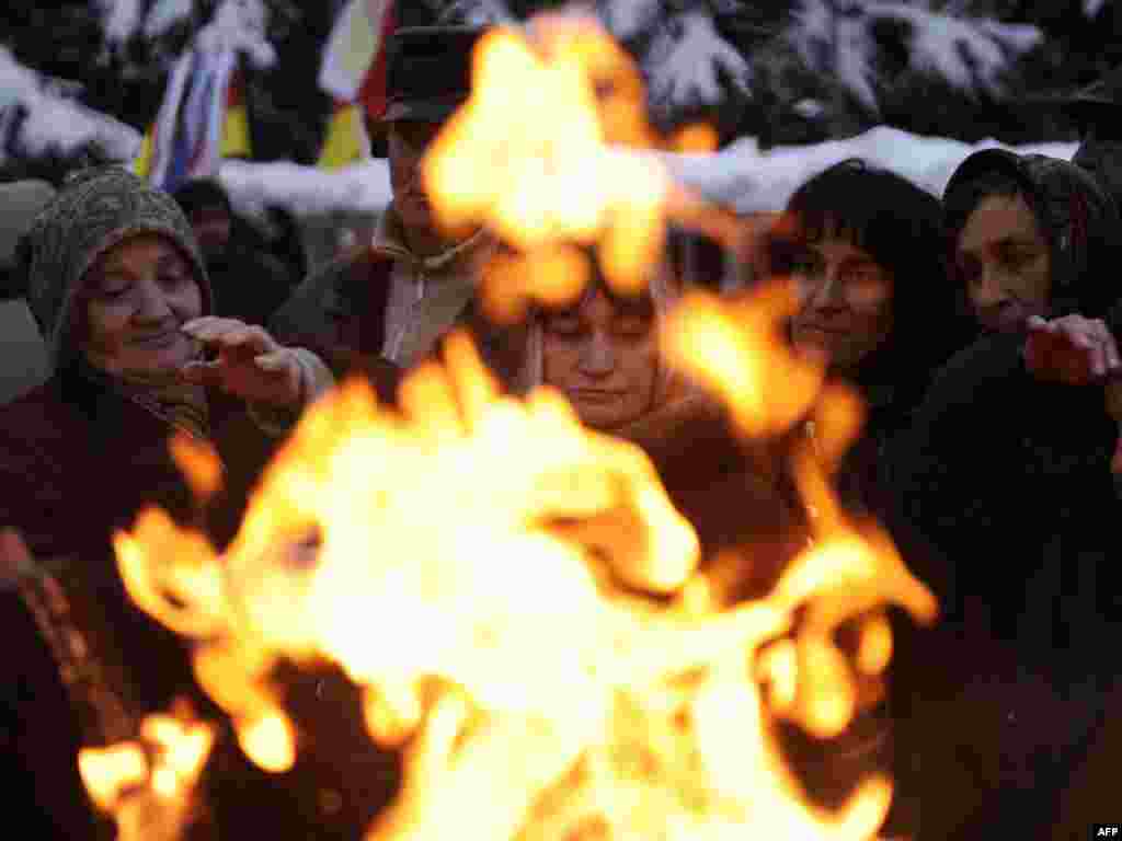 Supporters of South Ossetian presidential candidate Alla Dzhioyeva warm up near a fire during a rally in Tskhinvali after the November 27 vote was annulled by the breakaway Georgian republic&#39;s courts. (AFP Photo/ Mikhail Mordasov)