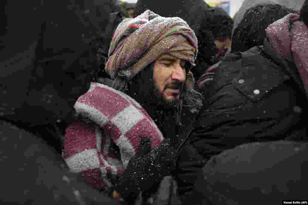 Grimaszol sorbanállás közben az egyik menekült, miközben havazik a boszniai menekülttáborban.