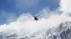 In this photo provided by Tasnim News Agency, a rescue helicopter flies over the Dena mountains while searching for wreckage of a plane that crashed on Sunday, in southern Iran, Monday, Feb. 19, 2018.