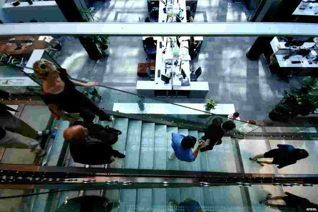 A group of students walks down the staircase leading into the Central Newsroom.