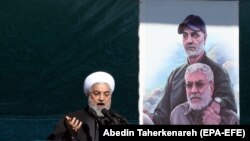 Hassan Rouhani speaks during a ceremony celebrating the 41st anniversary of the Islamic Revolution, on Azadi (Freedom) square in Tehran, February 11, 2020. Behind him is a poster showign Qassem Soleimani.