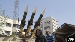 Iranians walk past Sam-6 missiles displayed in the street during a commemoration of the 1980-88 Iran-Iraq war, south of Tehran on September 26, 2016.