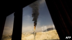 A gas flame is seen through a bus window at the South Pars gas field facilities in Iran's southern port of Assaluyeh.