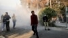 Protesters in Tehran react as a smoke grenade is thrown by Iranian police near the city's university last week. The Islamic Revolutionary Guards Corps says it has now quashed the unrest in the country which it blamed on foreign interference. 
