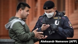 A man shows his digital ID to a Russian police officer amid a coronavirus lockdown on May 6.