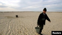 Житель села Каратерен Кызылординской области несет воду. 16 апреля 2005 года. 