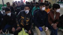 Иран мен Ауғанстан шекарасында бақылау бекетінен өткелі тұрған адамдар.