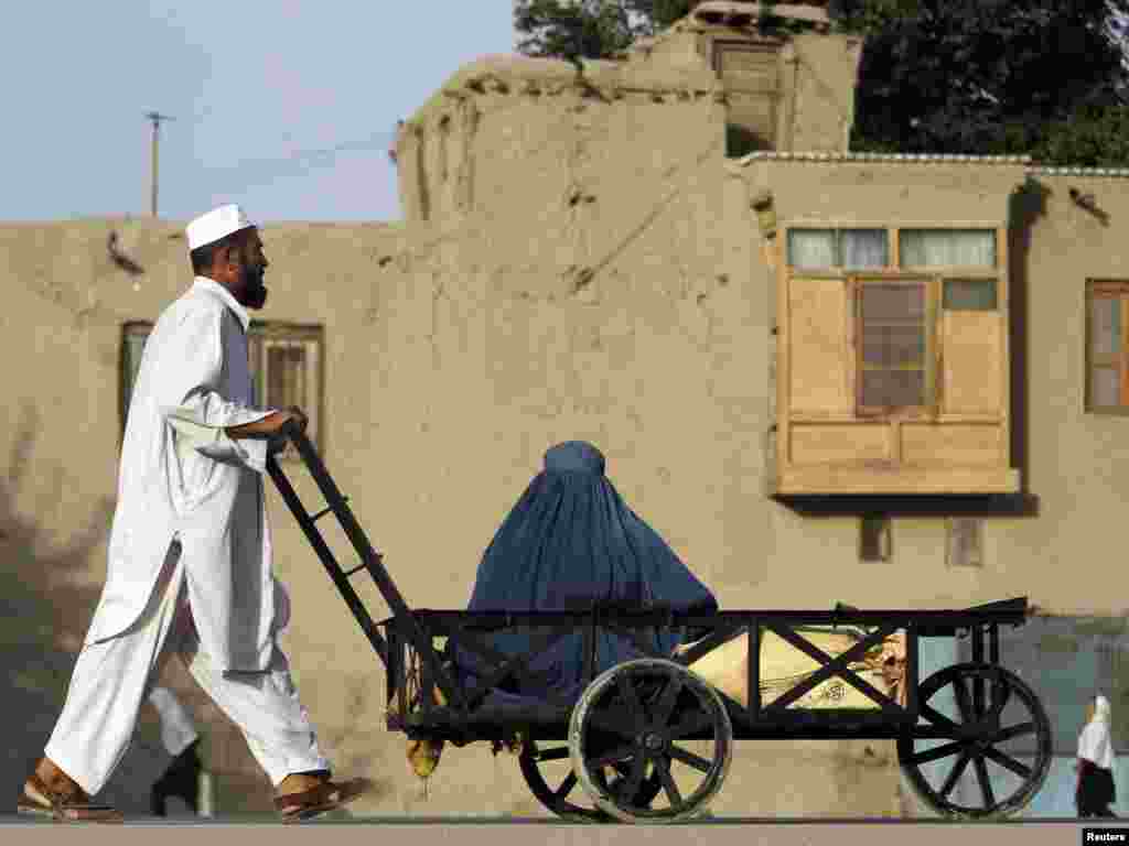 A woman sits in a handcart as her relative pushes it on the outskirts of Kabul on September 20. (Photo taken by Omar Sobhani for Reuters)