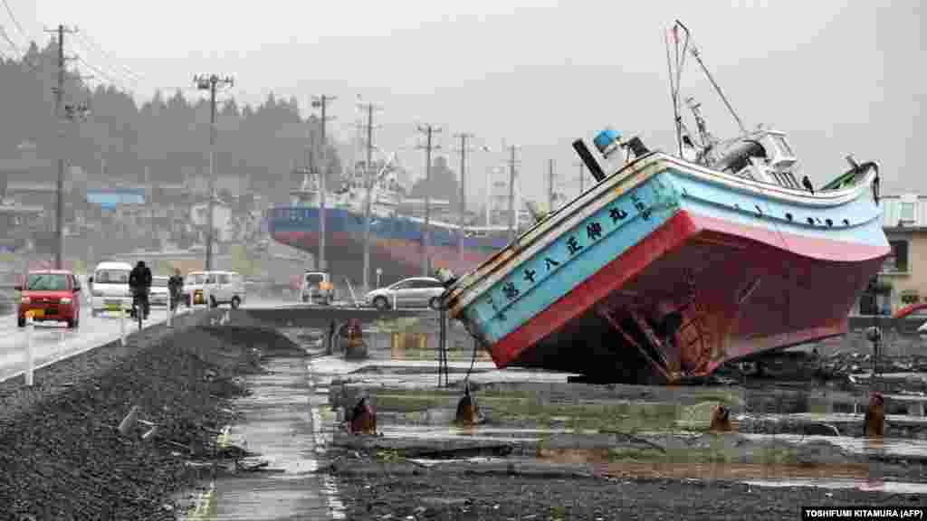 Vehicles move among fishing vessels that were carried from Kesennuma port by the March 11, 2011, tsunami, in the city of Kesennuma, Japan. (AFP/Toshifumi Kitamura)