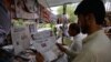 Një qytetar i Pakistanit duke lexuar një gazetë, në ballinës e së cilës është një artikull për presidentin amerikan Donald Trump. Islamabad, 23 gusht 