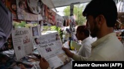 Një qytetar i Pakistanit duke lexuar një gazetë, në ballinës e së cilës është një artikull për presidentin amerikan Donald Trump. Islamabad, 23 gusht 