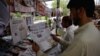 Pakistanis read newspapers with a front page headline about U.S. President Donald Trump at a stall in Islamabad on August 23.