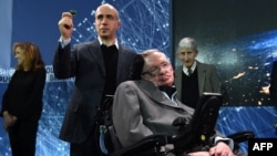 Yury Milner holds up a "Starchip" in the presence of renowned cosmologist Stephen Hawking in New York on April 12