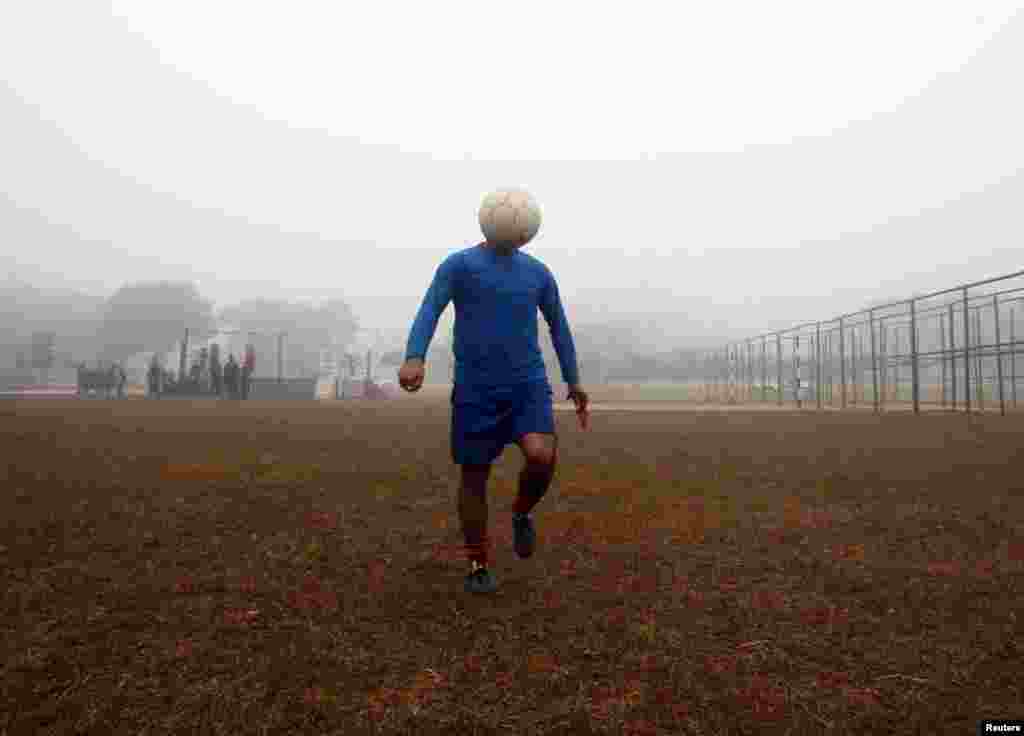 A man controls a ball during his soccer practice in a public park on a foggy morning in Agartala, capital of India&#39;s northeastern state of Tripura. (Reuters/Jayanta Dey)