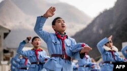 Китайские школьники поют песню на церемонии подъема флага в школе. Провинция Сычуань, 21 января 2015 года.