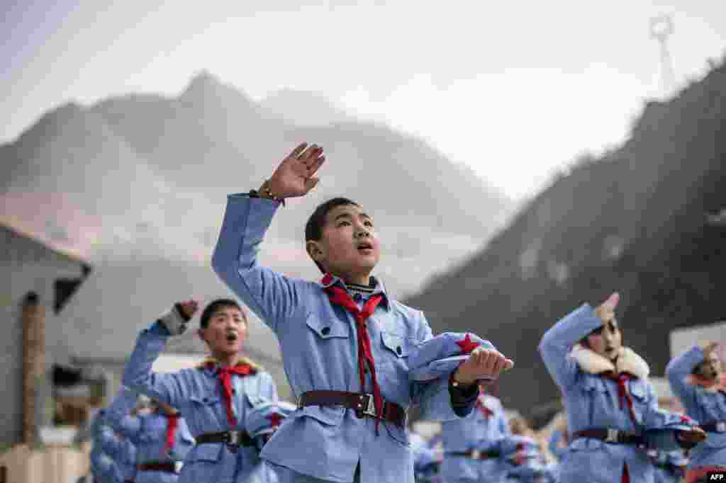 Children dressed in uniform sing after raising the national flag at the Beichuan Red army elementary school in Beichuan, southwest Sichuan Province, China. (AFP/Fred Dufour)